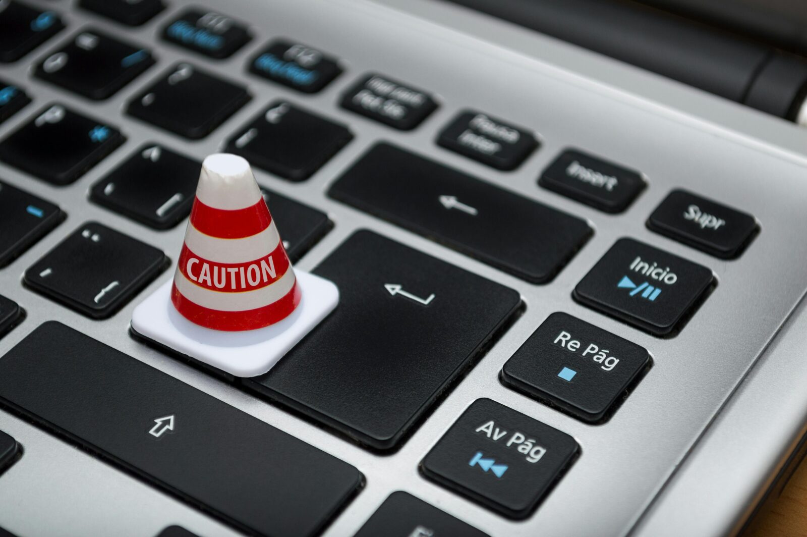 small red and White Caution Cone on Keyboard