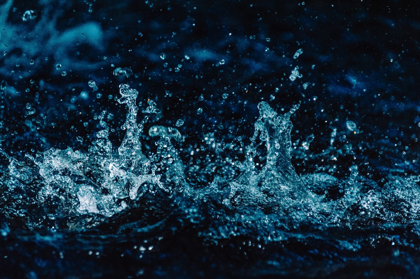 Captivating close-up of water splashing in a dark, moody setting, showcasing vivid textures.